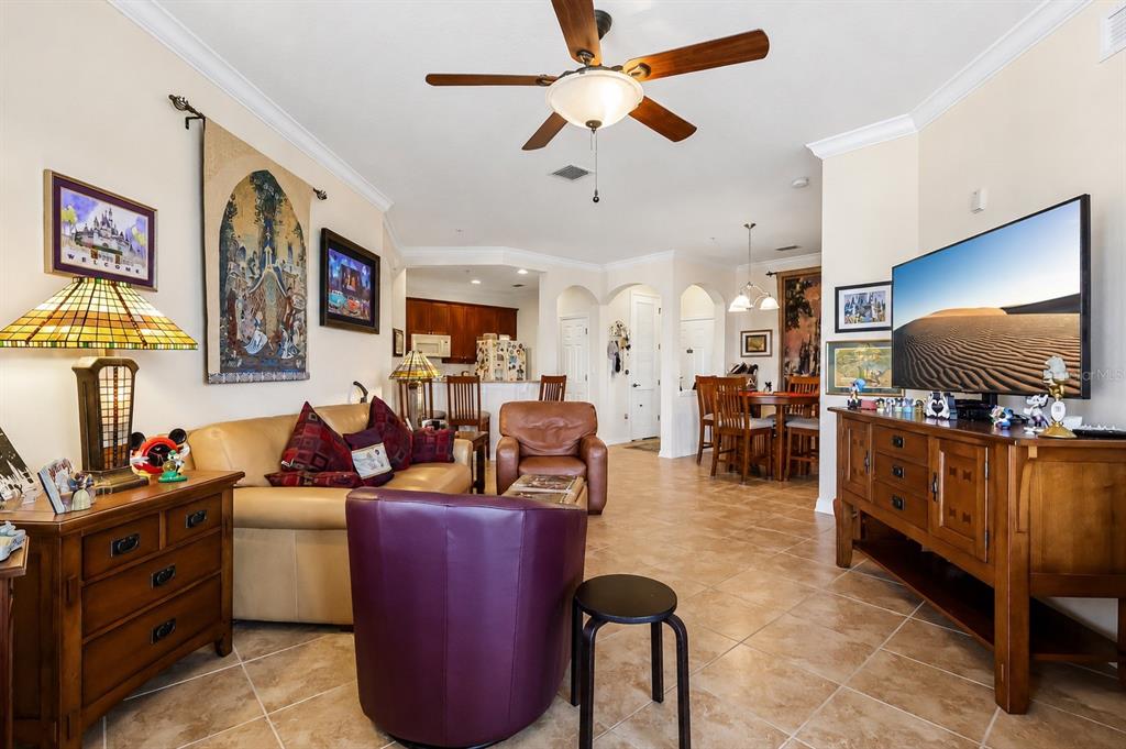 A living room with tile floors, a ceiling fan, leather furniture, and a television console — 8168 BOAT HOOK LOOP UNIT 303, WINDERMERE, FL