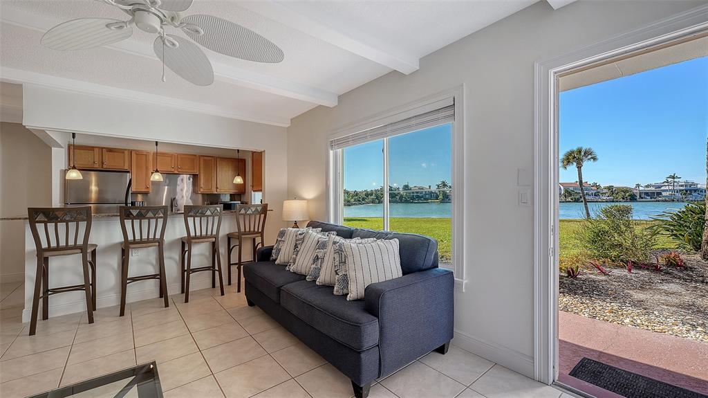 A living room with a blue sofa and breakfast bar overlooks a waterfront view — 761 JOHN RINGLING BOULEVARD UNIT 5, SARASOTA, FL