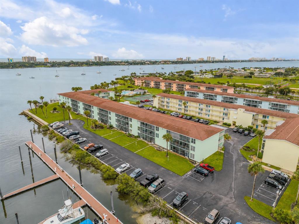 An aerial view shows a multi-story apartment complex with a parking lot and boat docks — 715 S BEACH STREET UNIT 214D, DAYTONA BEACH, FL