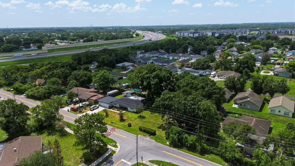 An aerial view shows a residential neighborhood with houses, trees, and a nearby highway — MILLINOCKETT LANE, ORLANDO, FL