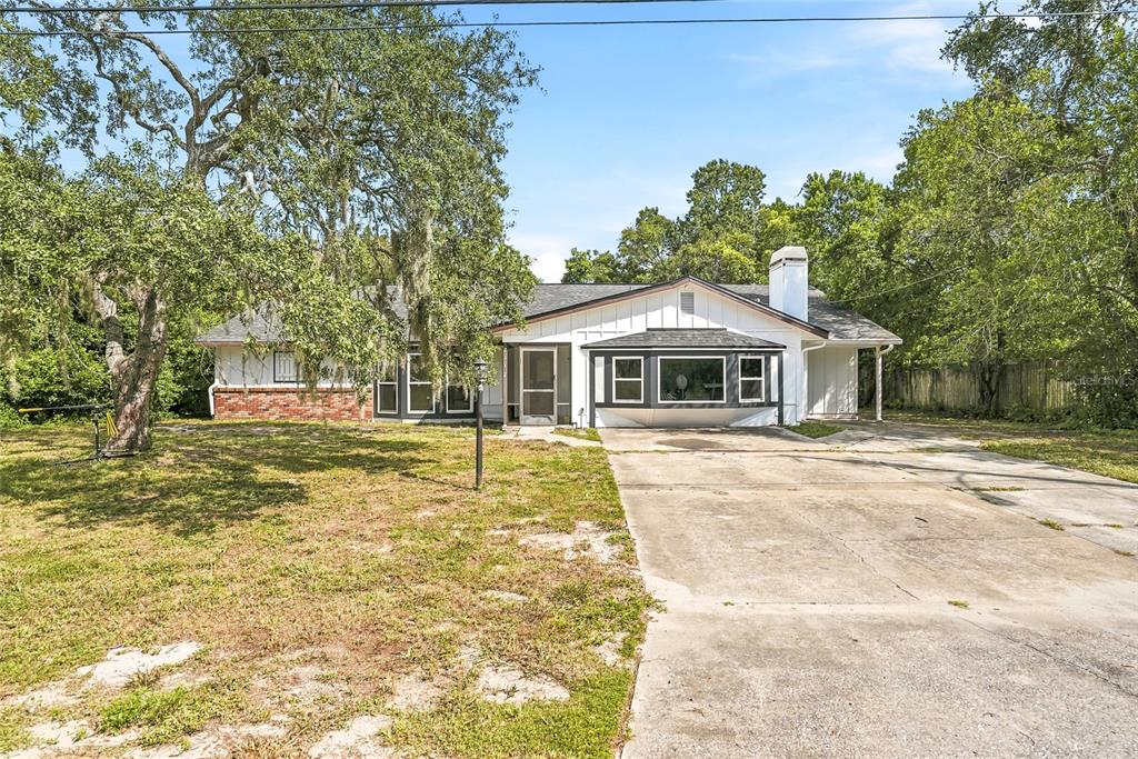 A single-story house with a brick and white exterior, a bay window, and a concrete driveway — 2112 MEADOW LARK ROAD, SPRING HILL, FL