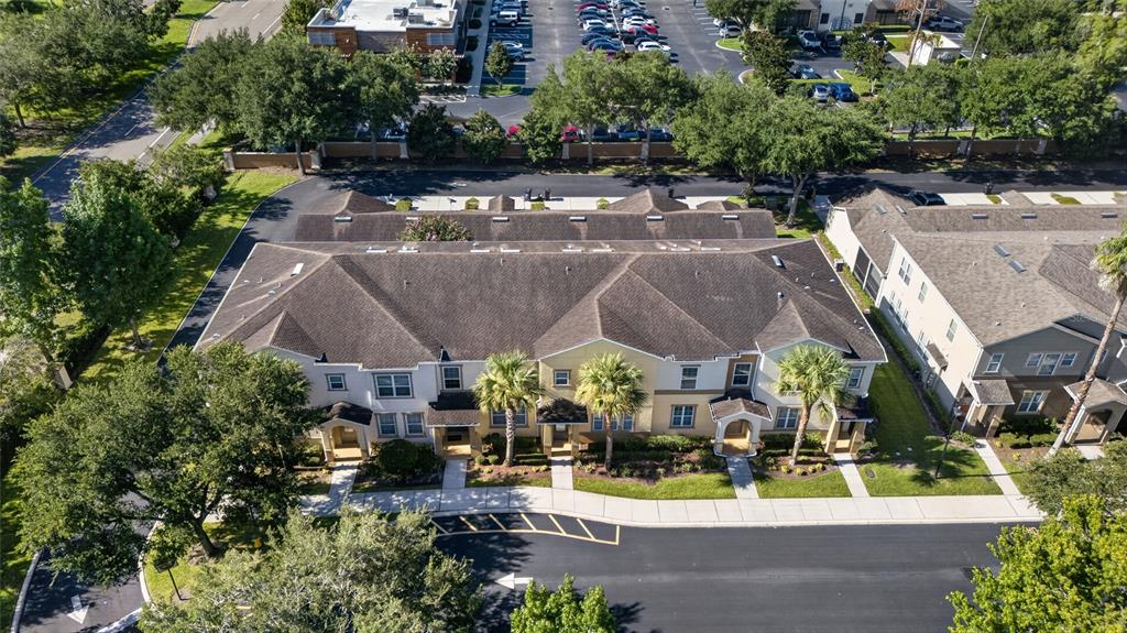 An aerial view shows a multi-unit residential building with a brown roof and palm trees — 865 BELLES FERRY LOOP, SANFORD, FL
