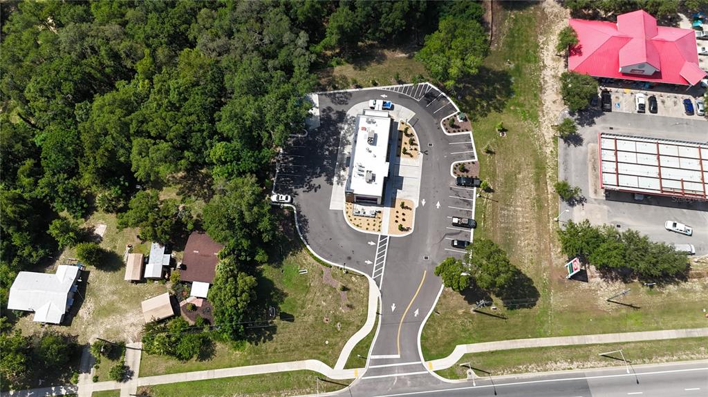 An aerial view shows a commercial building with a drive-thru lane and parking lot — 1129 STATE ROAD 20, INTERLACHEN, FL