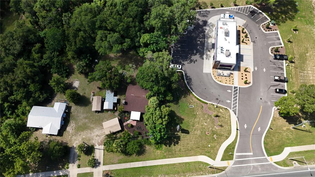 An aerial view shows a commercial building with a parking lot next to residential properties — 1129 STATE ROAD 20, INTERLACHEN, FL