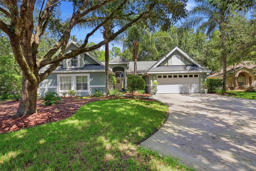 A single-story house with a green exterior, a two-car garage, and a large front lawn — 1490 BENT OAKS BOULEVARD, DELAND, FL