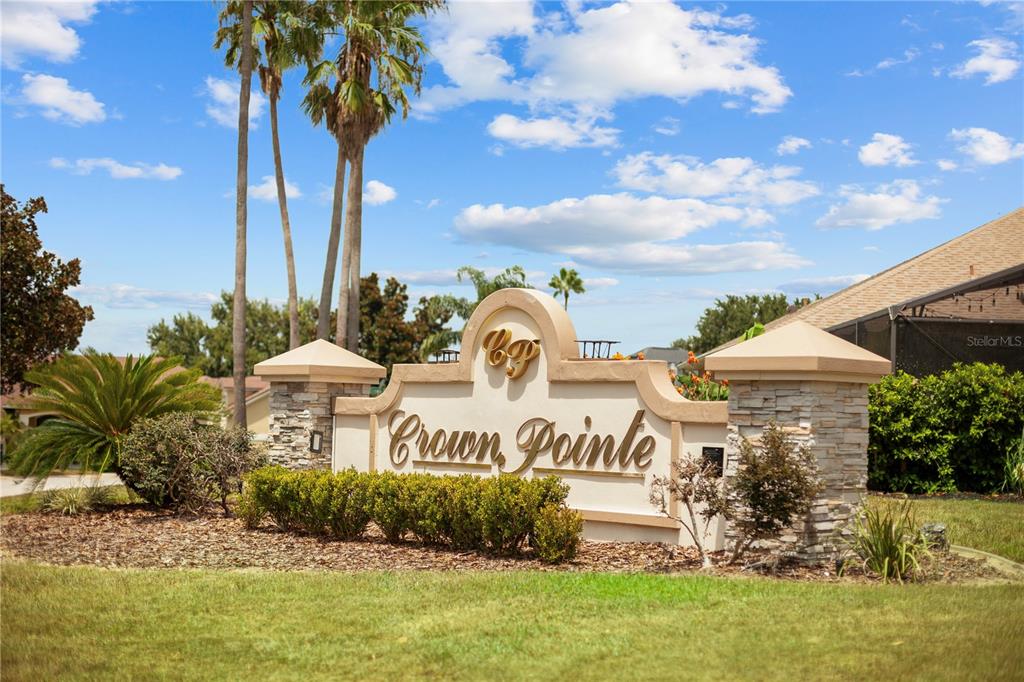A stone and stucco monument sign for Crown Pointe stands in a landscaped yard — 12615 CROWN POINT CIRCLE, CLERMONT, FL