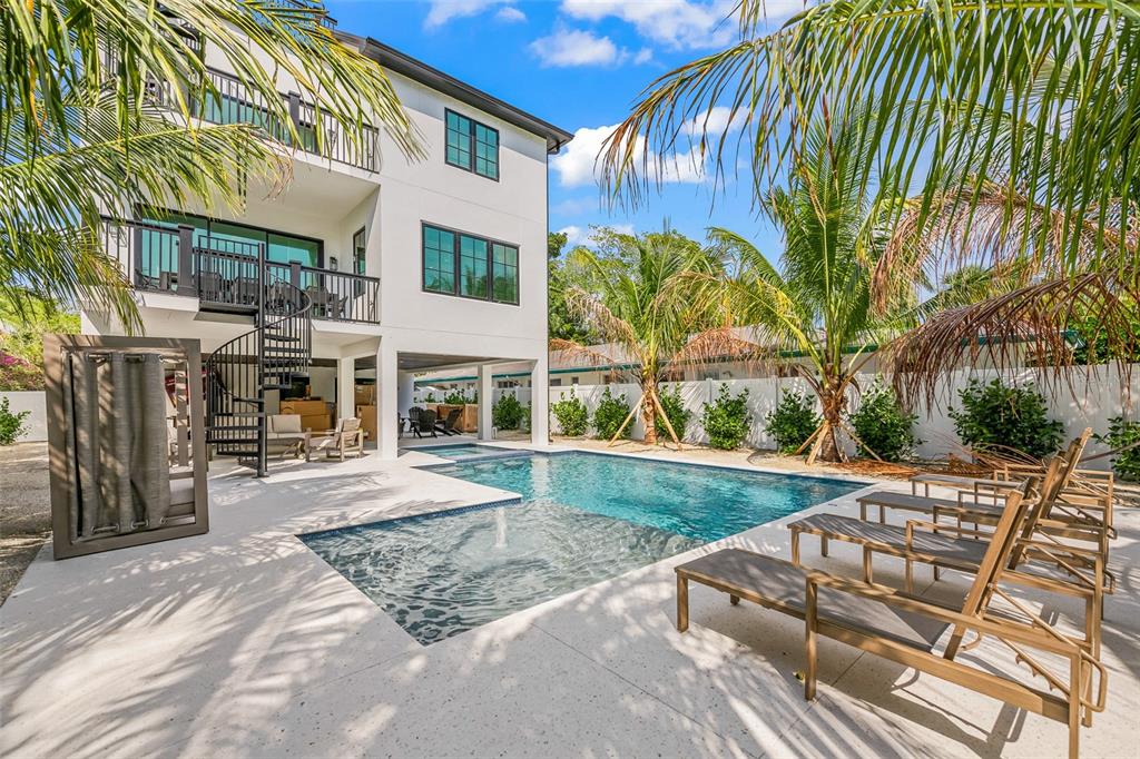 A multi-story house with a spiral staircase, swimming pool, and lounge chairs on a patio — 128 FILLMORE DRIVE, SARASOTA, FL