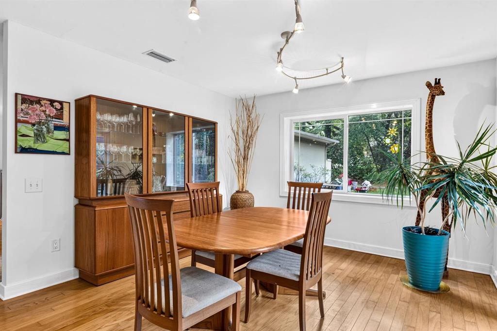A room with light wood flooring, a large window, and built-in wooden cabinetry — 11101 NW 12TH PLACE, GAINESVILLE, FL
