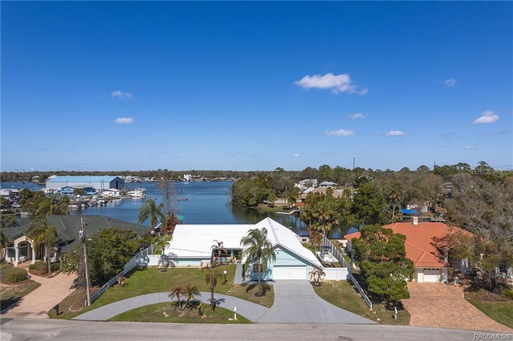 An aerial view shows a light blue house with a white roof near a waterway — 171 SW 3RD STREET, CRYSTAL RIVER, FL