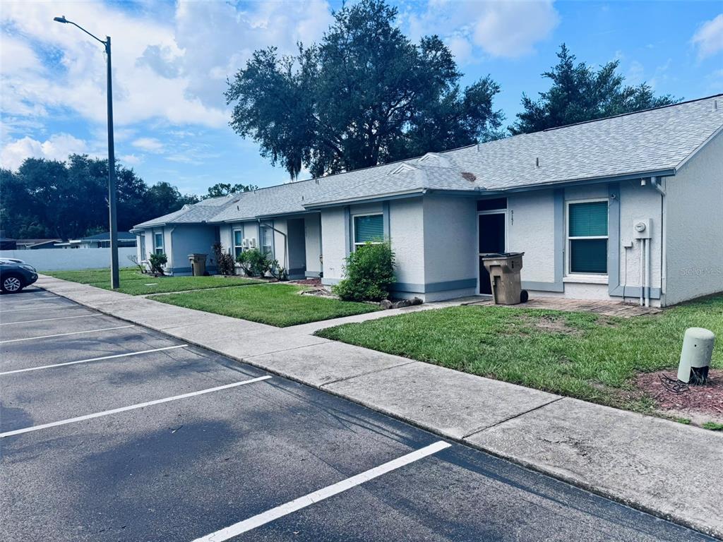 A single-story residential building with a gray roof, light-colored stucco walls, and a parking lot — 5151 GAINSVILLE DRIVE, TEMPLE TERRACE, FL