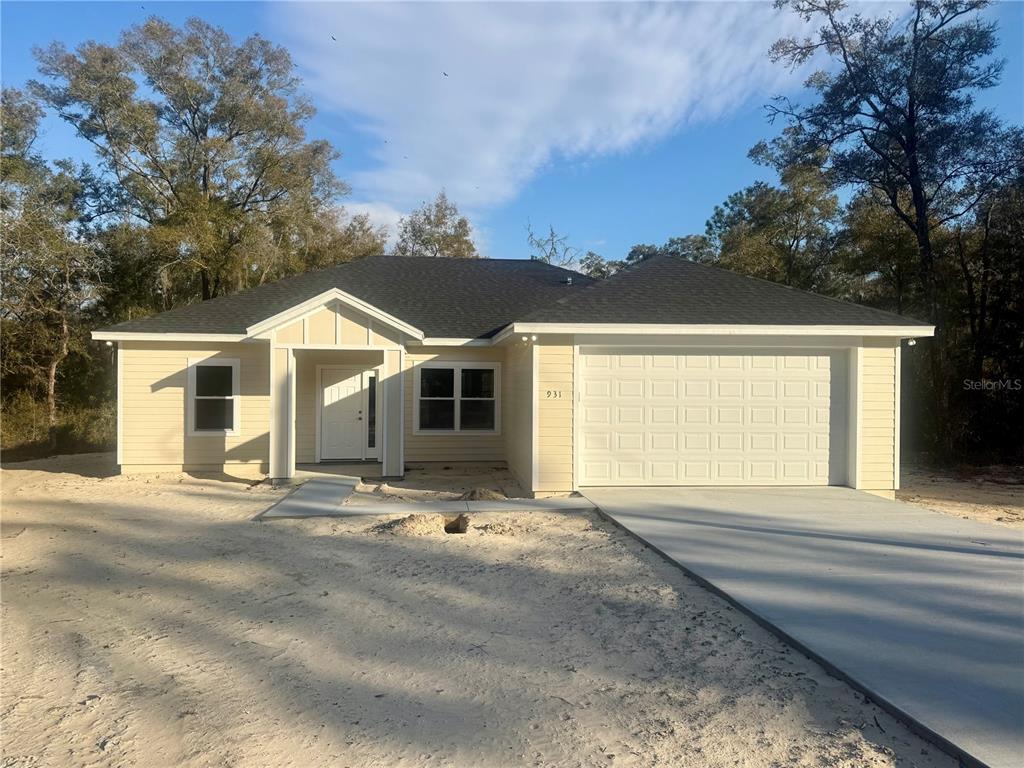 An open-concept dining area features gray wood-look flooring, a chandelier, and an adjacent kitchen — 931 NE 154TH TERRACE, WILLISTON, FL