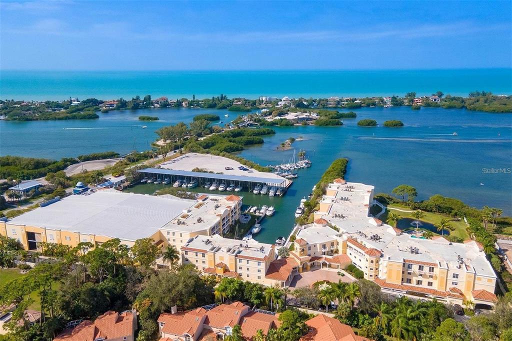 An aerial view of a waterfront residential complex with a boat slip and marina — 570 BLACKBURN POINT ROAD UNIT 43, OSPREY, FL
