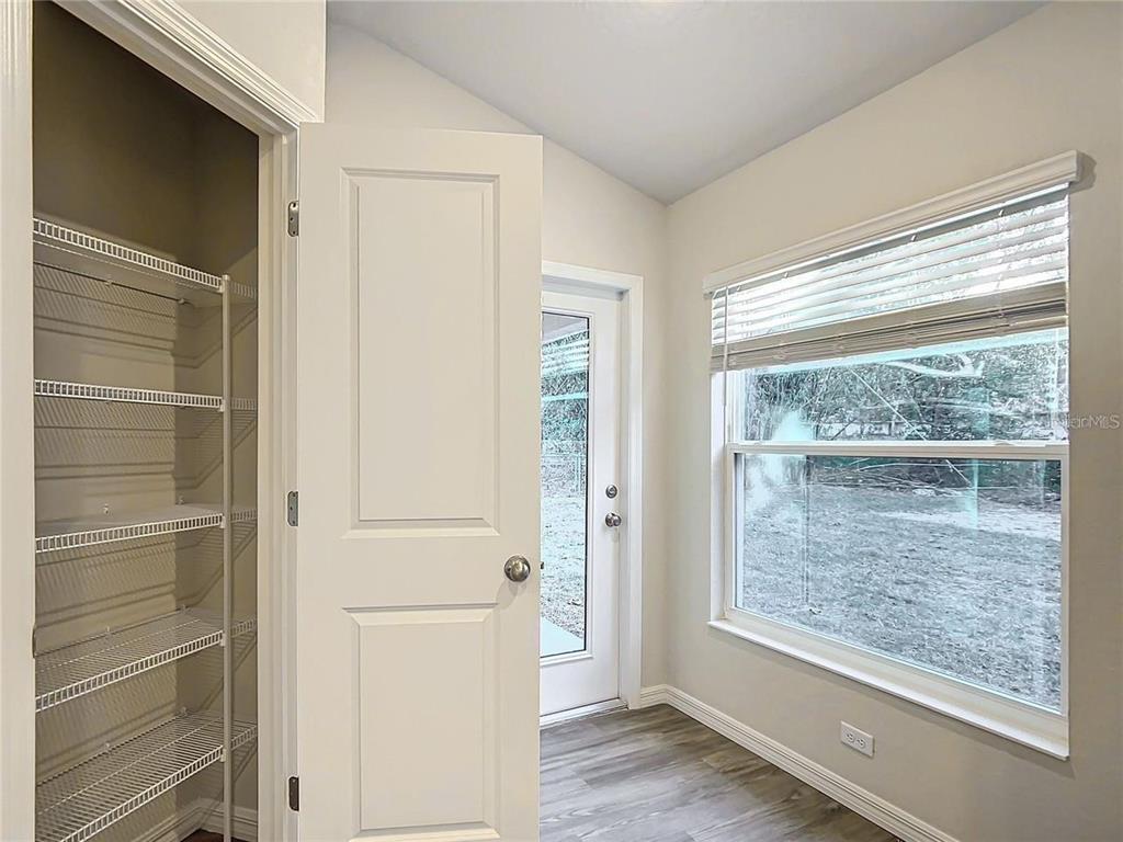 A room with a white door, a wire-shelved pantry, and a window overlooking a yard — 3070 E ODIER STREET, INVERNESS, FL