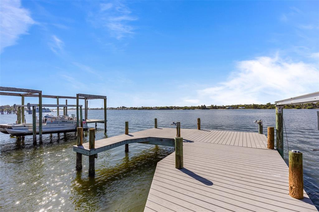 A wooden boat dock extends into a calm body of water under a blue sky — 25 VIP ISLAND, GRANT, FL