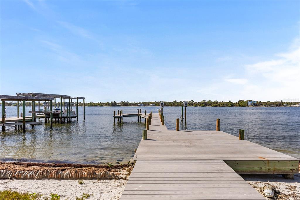 A wooden dock extends into a calm body of water from a sandy shore — 25 VIP ISLAND, GRANT, FL