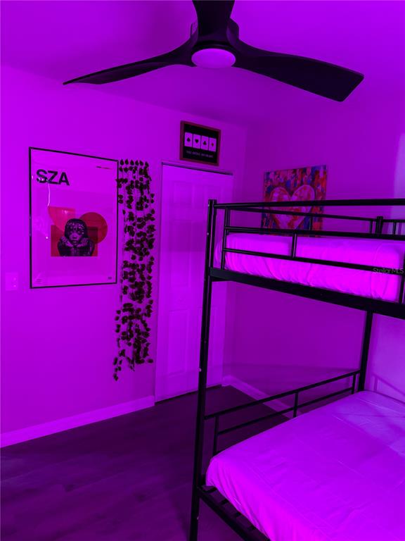 A bedroom features a black metal bunk bed, a SZA poster, and purple ambient lighting — 370 HAND AVE, ORMOND BEACH, FL