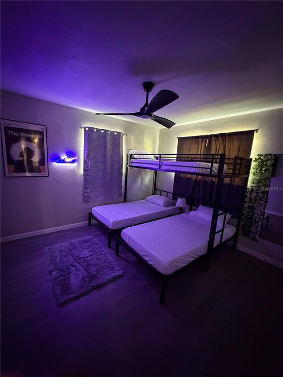 A bedroom features a black metal bunk bed, a ceiling fan, and purple accent lighting — 370 HAND AVE, ORMOND BEACH, FL