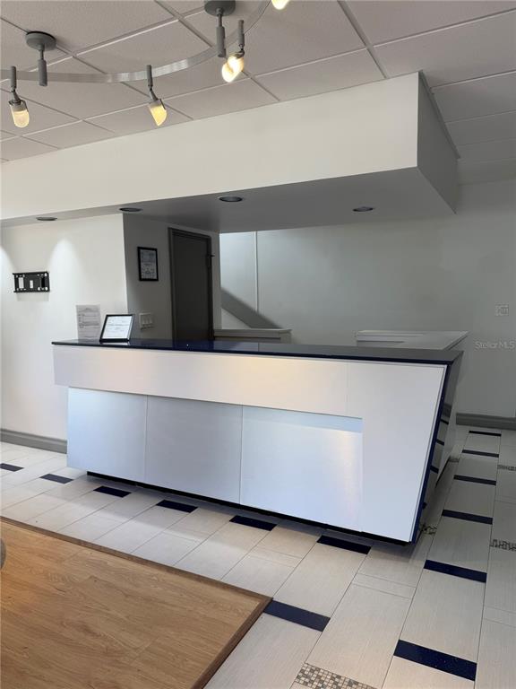 A modern white reception desk sits on a tiled floor in a commercial office space — 330 E CENTRAL BOULEVARD, ORLANDO, FL
