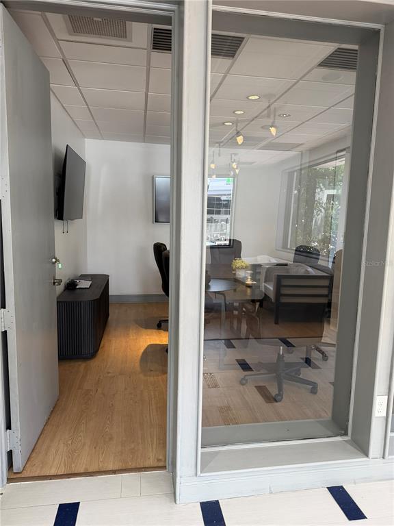 A view through an open door into a modern office with a conference table and chairs — 330 E CENTRAL BOULEVARD, ORLANDO, FL