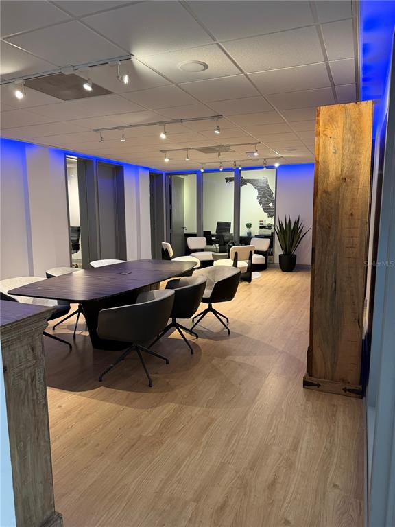 A modern office conference room features a dark wood table, swivel chairs, and blue lighting — 330 E CENTRAL BOULEVARD, ORLANDO, FL