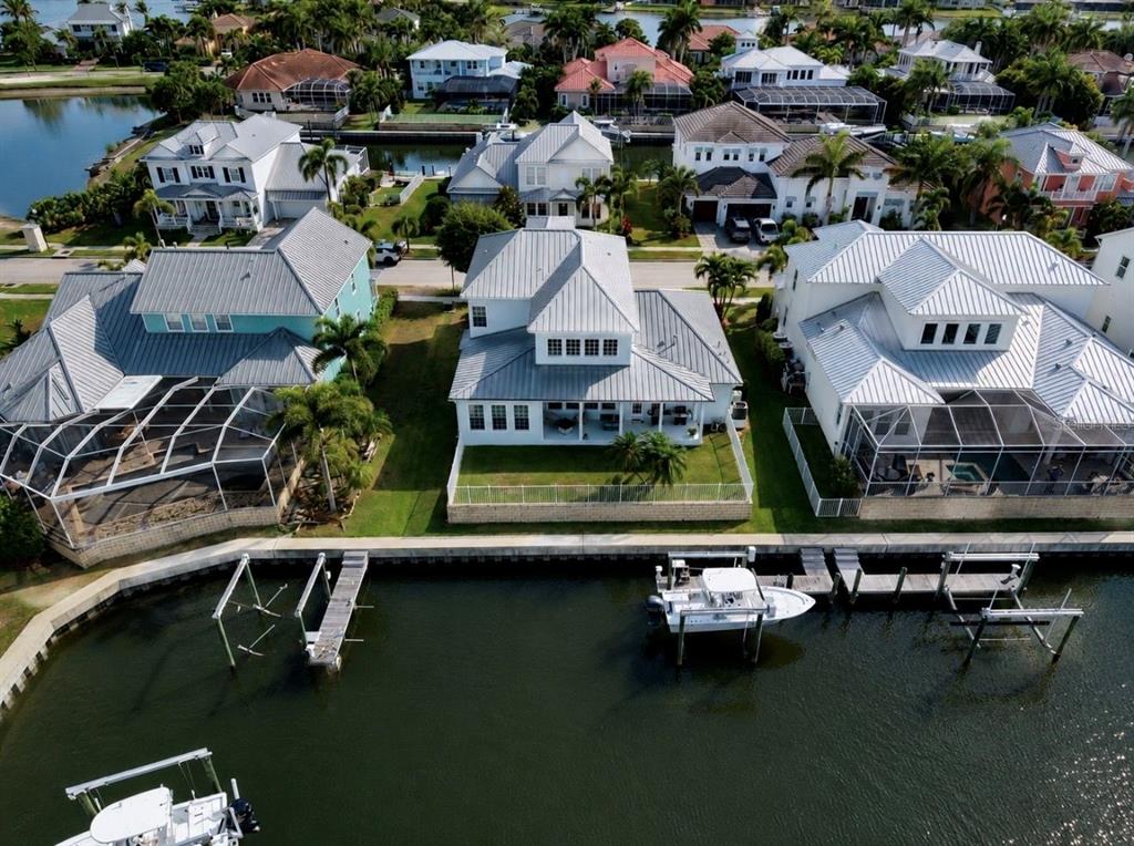An aerial view of waterfront houses with metal roofs, private docks, and swimming pool enclosures — 611 MIRABAY BOULEVARD, APOLLO BEACH, FL