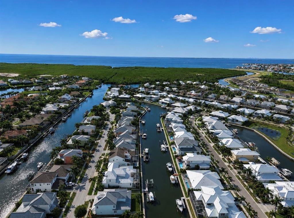 An aerial view shows waterfront houses with boat docks lining canals leading to the ocean — 611 MIRABAY BOULEVARD, APOLLO BEACH, FL