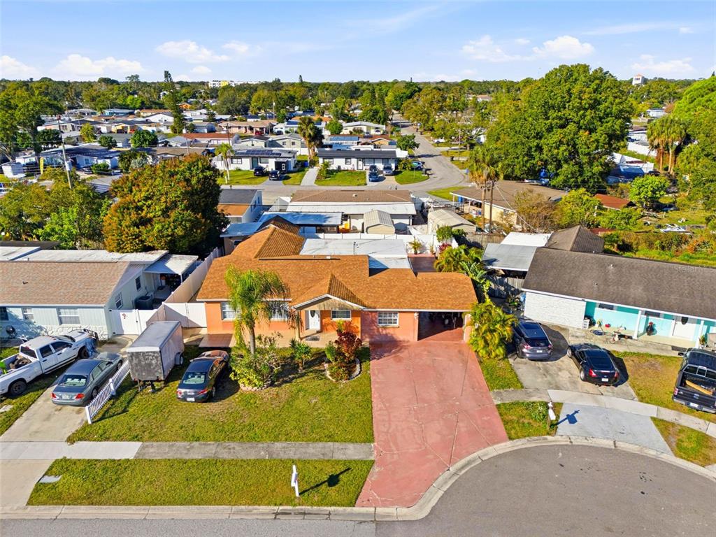 A single-story peach-colored house with a palm tree, a driveway, and a one-car garage — 4914 HOLIDAY DRIVE, TAMPA, FL