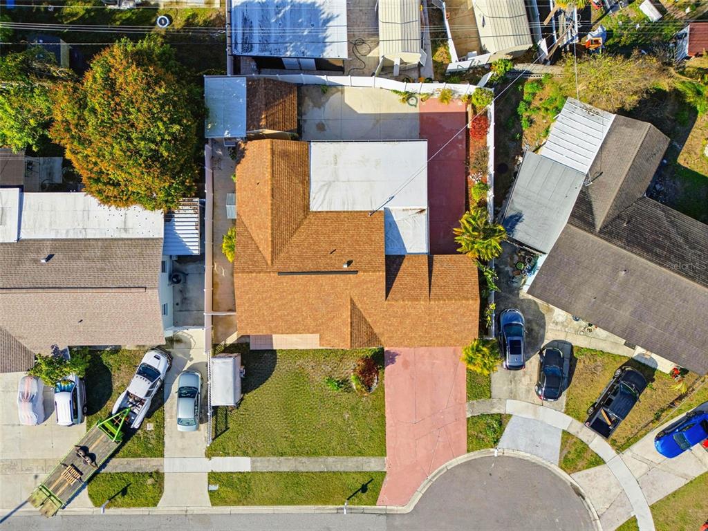 An aerial view shows a single-story orange house with a brown roof and a driveway — 4914 HOLIDAY DRIVE, TAMPA, FL
