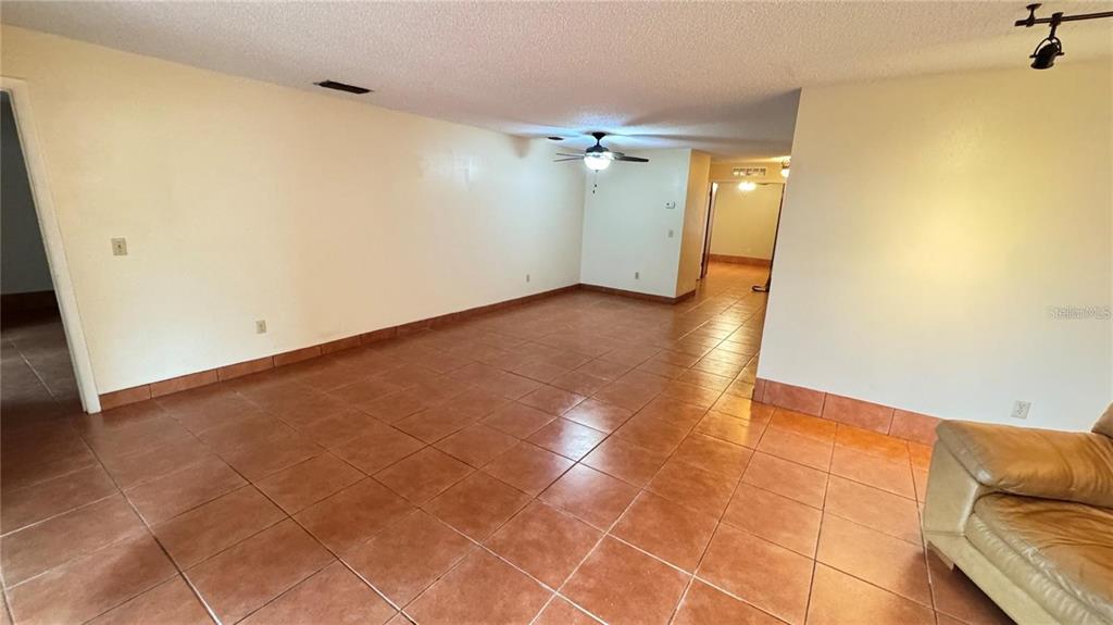 An interior view of a living room with terracotta tile flooring and a ceiling fan — 2657 EXUMA WAY, WINTER PARK, FL