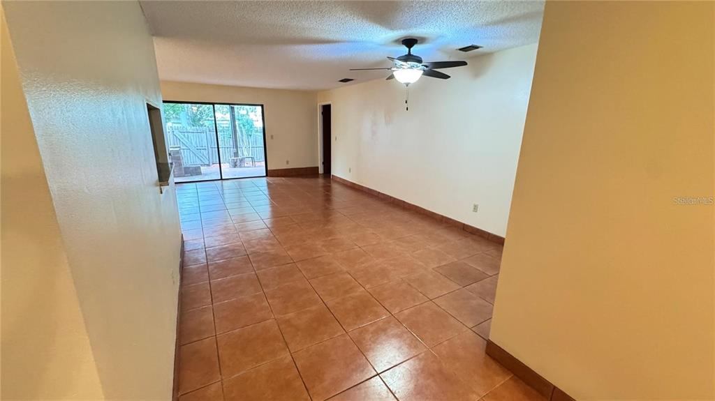 An interior view of a living area with tile flooring, a ceiling fan, and sliding doors — 2657 EXUMA WAY, WINTER PARK, FL