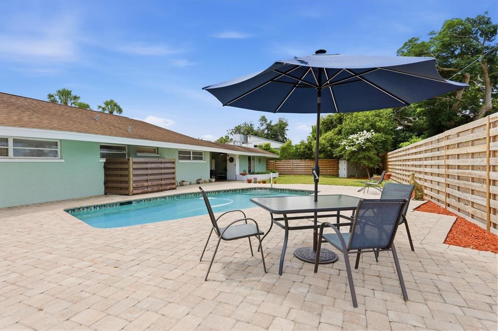 A single-story house with a brown roof, light green siding, and palm trees in front — 3612 S LOCKWOOD RIDGE ROAD, SARASOTA, FL
