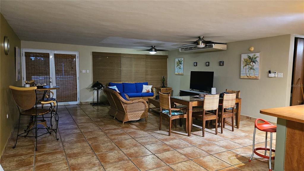 A living and dining area features tile floors, wicker furniture, and a blue sofa — C-201 PALMA VISTA COND, FAJARDO, PR