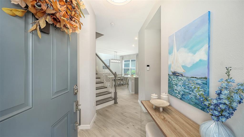 A view from an entryway into a home featuring a staircase and a dining area — 15336 ISLA PALMA LANE, NOKOMIS, FL