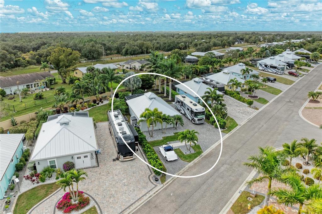 An aerial view shows a house with a metal roof, two RVs, and a vintage car — 8688 SW SAND CRANE CIRCLE LOT 44, ARCADIA, FL