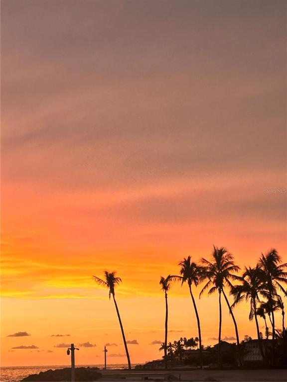 A sunset view over the ocean with waves washing onto a sandy beach — 7740 SANDERLING ROAD, SARASOTA, FL