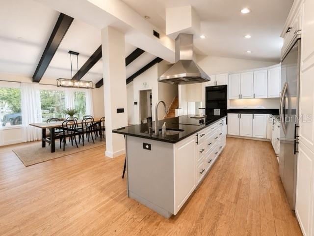 A modern kitchen with a large island, stainless steel range hood, and white cabinetry — 1909 OLD SAWMILL ROAD, BRANDON, FL