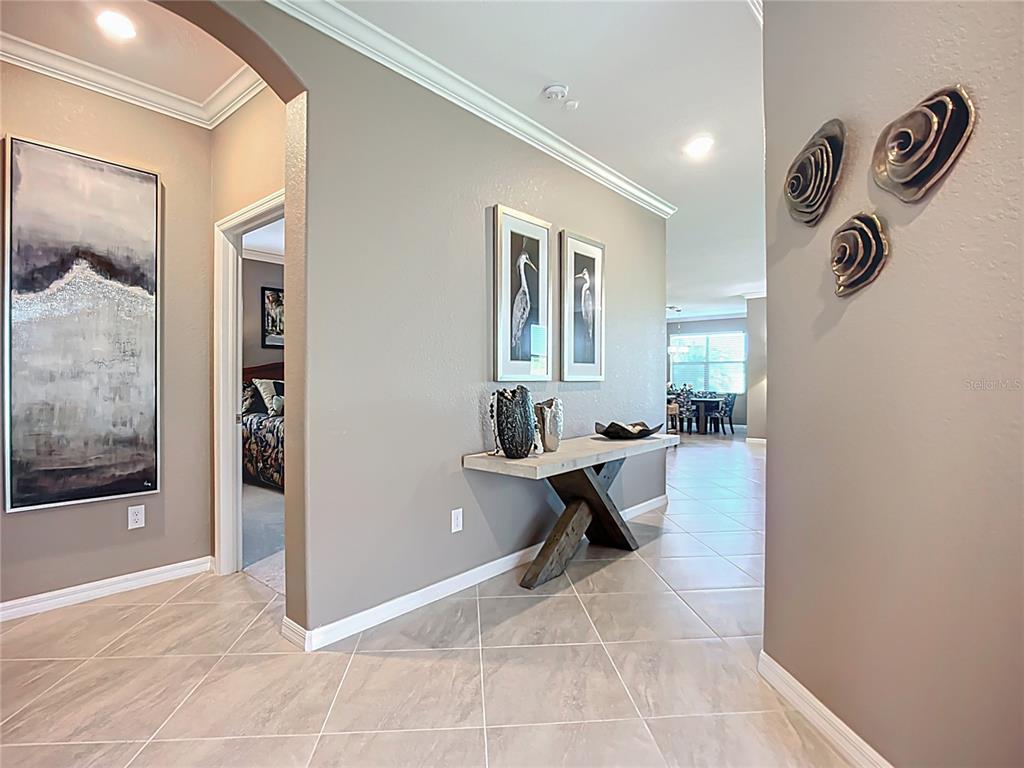 A tiled entryway features a console table, wall art, and a view into a living area — 24137 SPARTINA DRIVE, VENICE, FL