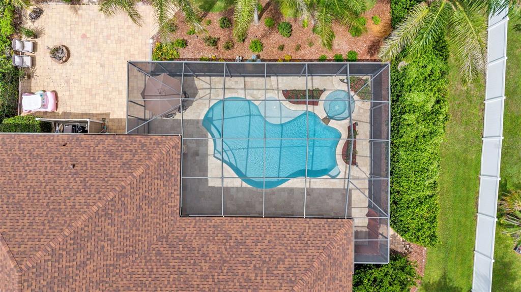 An aerial view shows a house with a screened-in pool, patio, and backyard landscaping — 2943 OAK TREE LANE, LAKELAND, FL