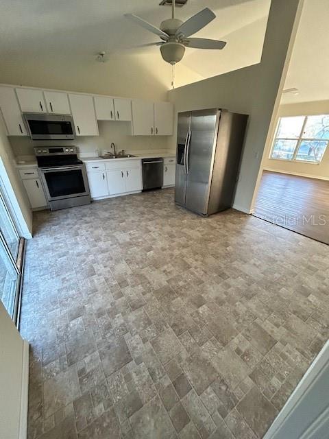 A kitchen features white cabinets, stainless steel appliances, and light-colored tile flooring — 5814 BRICKELL DRIVE, NORTH PORT, FL