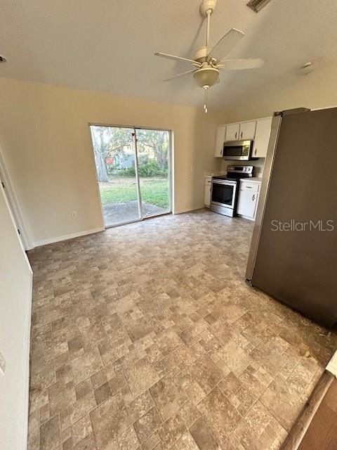 A kitchen with tile flooring, stainless steel appliances, and a sliding glass door to the yard — 5814 BRICKELL DRIVE, NORTH PORT, FL