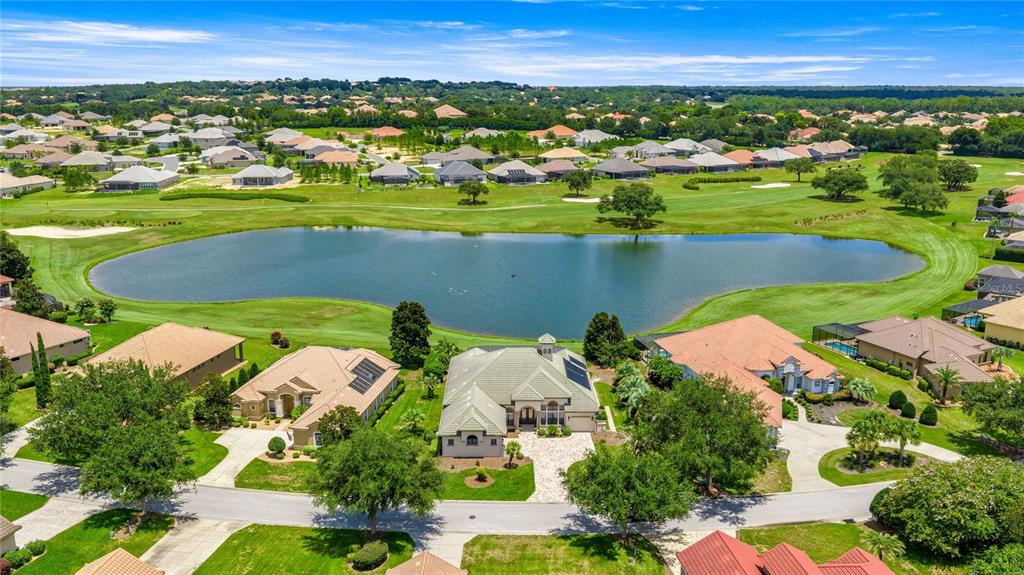 An aerial view shows a residential neighborhood with houses surrounding a central pond and golf course — 1575 N EAGLE RIDGE PATH, HERNANDO, FL