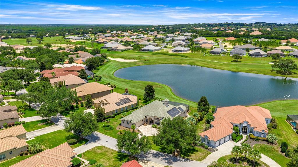 An aerial view shows several suburban houses surrounding a large pond on a golf course — 1575 N EAGLE RIDGE PATH, HERNANDO, FL