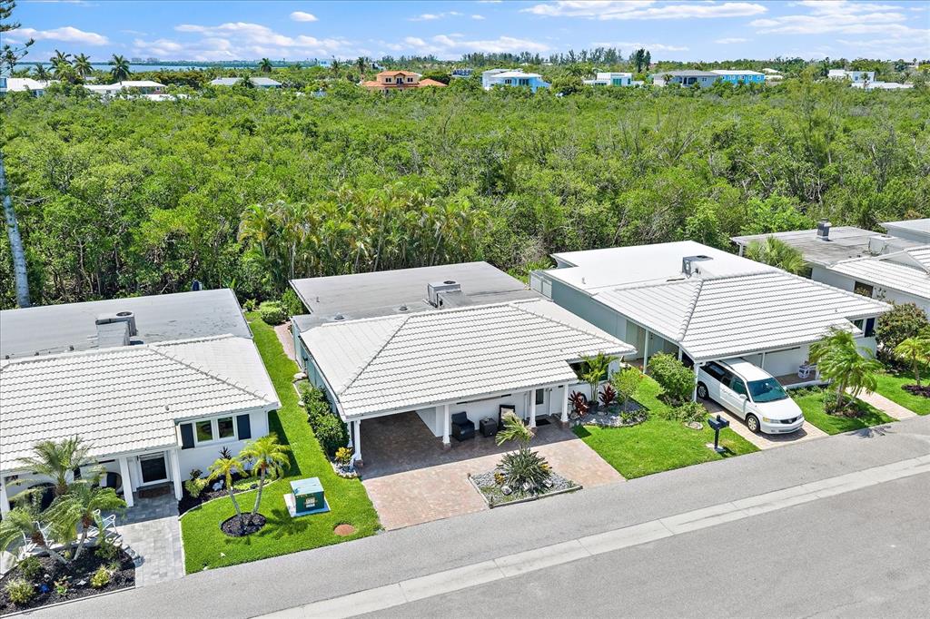 An aerial view shows three single-story houses with white tiled roofs and attached carports — 820 SPANISH DRIVE S UNIT ., LONGBOAT KEY, FL