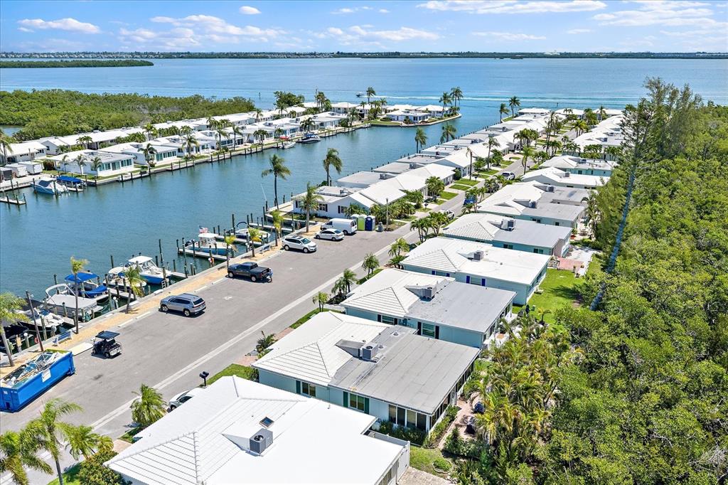 An aerial view shows a waterfront community with houses, boat slips, and a canal — 820 SPANISH DRIVE S UNIT ., LONGBOAT KEY, FL