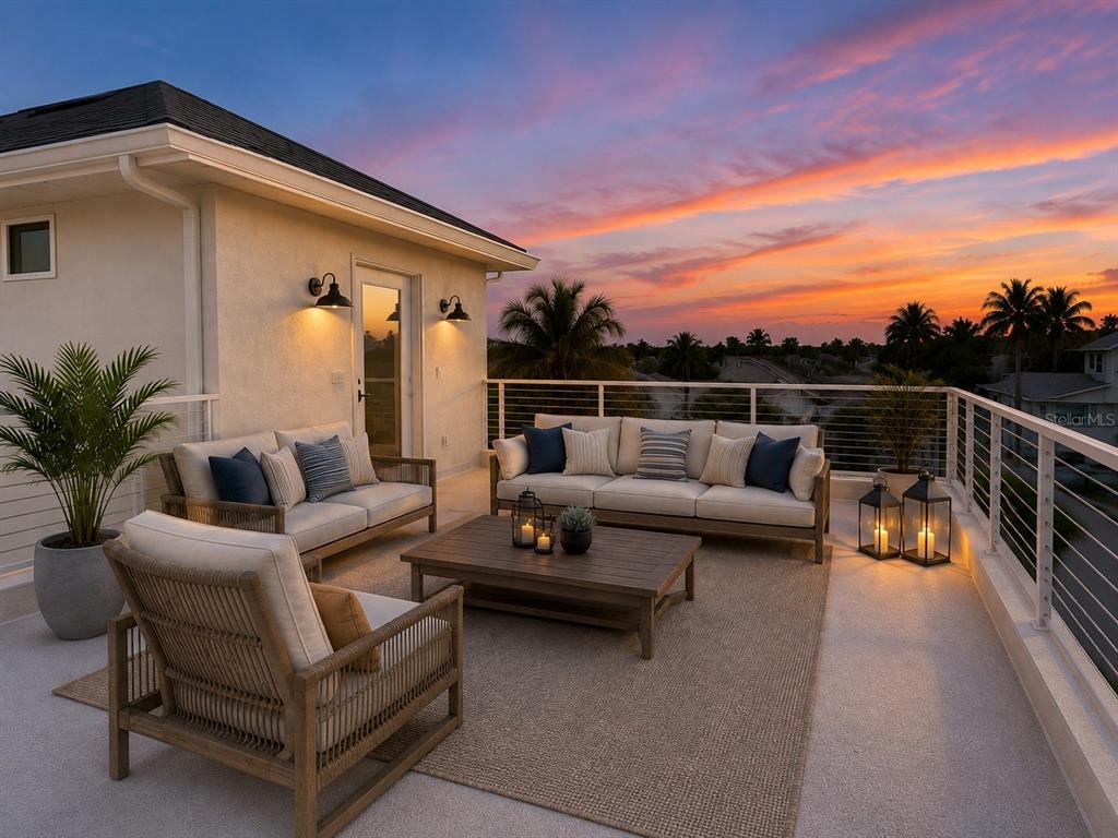 A rooftop terrace features outdoor furniture, a coffee table, and lanterns against a sunset sky — 19101 GULF BOULEVARD, INDIAN SHORES, FL