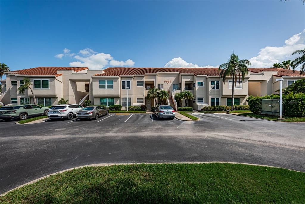 A multi-story apartment building with a tiled roof and a parking lot in front — 6020 BAHIA DEL MAR CIRCLE UNIT 226, ST PETERSBURG, FL