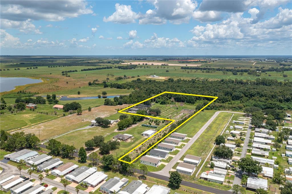 An aerial view shows a large, yellow-outlined plot of land adjacent to a residential neighborhood — 0 KEEN ROAD, FROSTPROOF, FL
