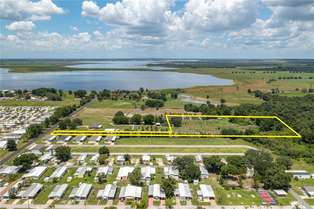 An aerial view shows a large rectangular plot of land outlined in yellow near water — 0 KEEN ROAD, FROSTPROOF, FL