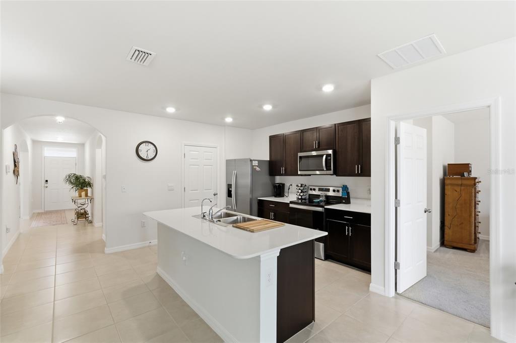 A kitchen with dark cabinets, white countertops, a central island, and tile flooring — 5708 BANNOCK CIRCLE, NORTH PORT, FL