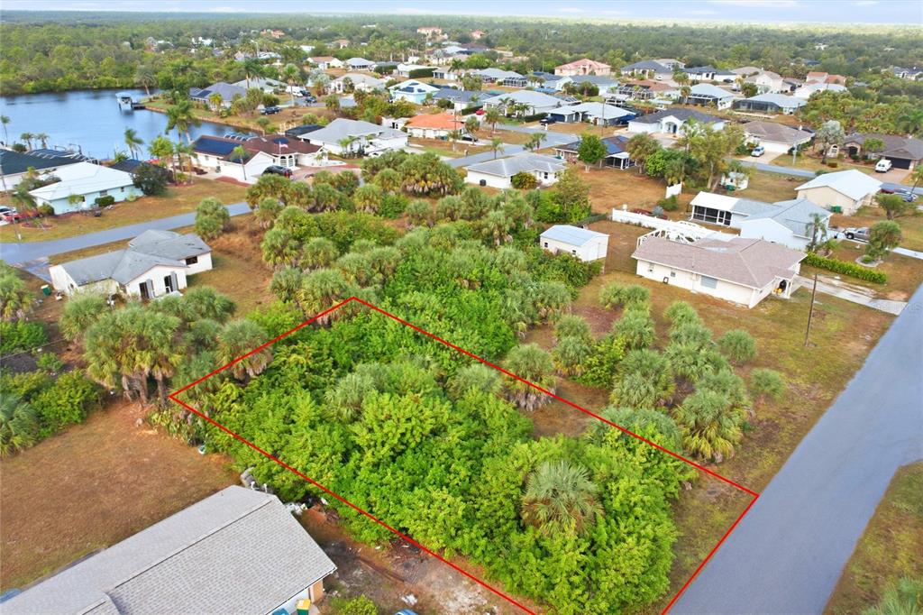 An aerial view shows a rectangular, tree-covered vacant lot outlined in red between residential houses — 4073 ROSE ARBOR CIRCLE, PORT CHARLOTTE, FL